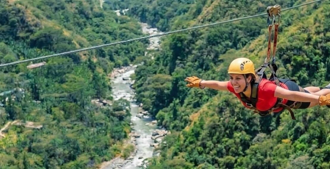 Viajera realizando tirolesa sobre el cañón en la portada del Inca Jungle Tour hacia Machu Picchu. Aventura en Cusco.