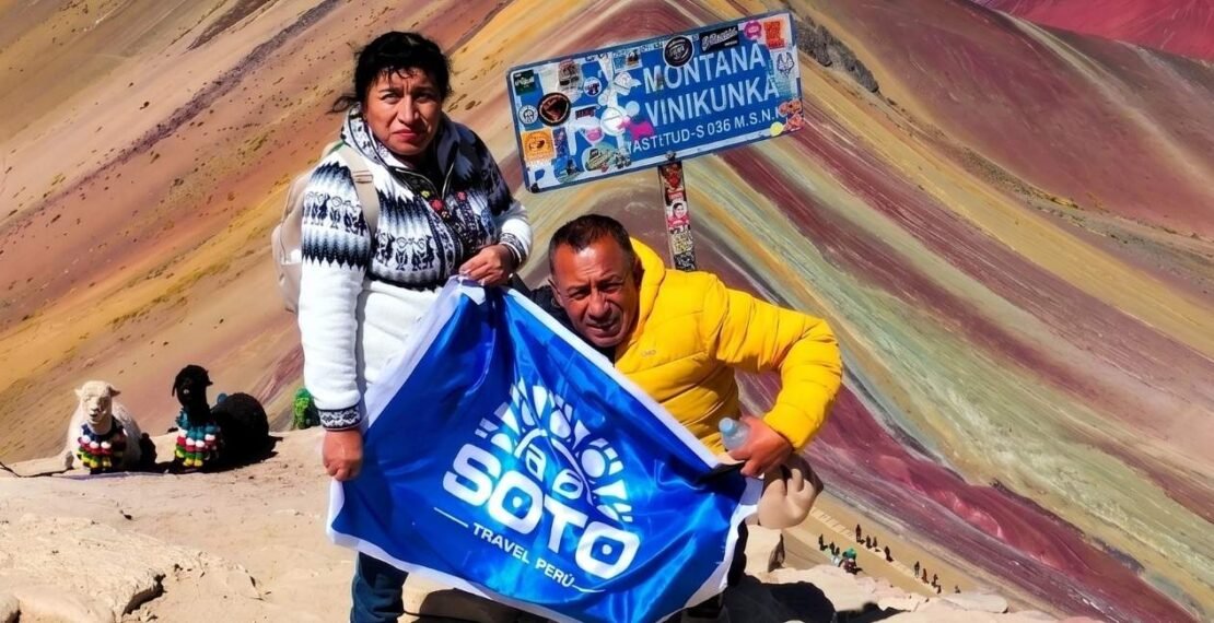 Viajeros con la bandera en la cumbre en la portada del tour de la montaña de colores. Viajes en Cusco.