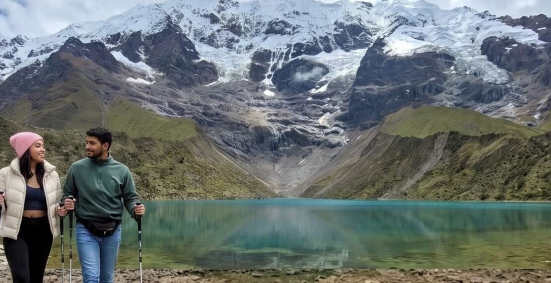 Pareja de viajeros realizando caminata con bastones en la portada de la excursión a la laguna Humantay. Viajes en Cusco.