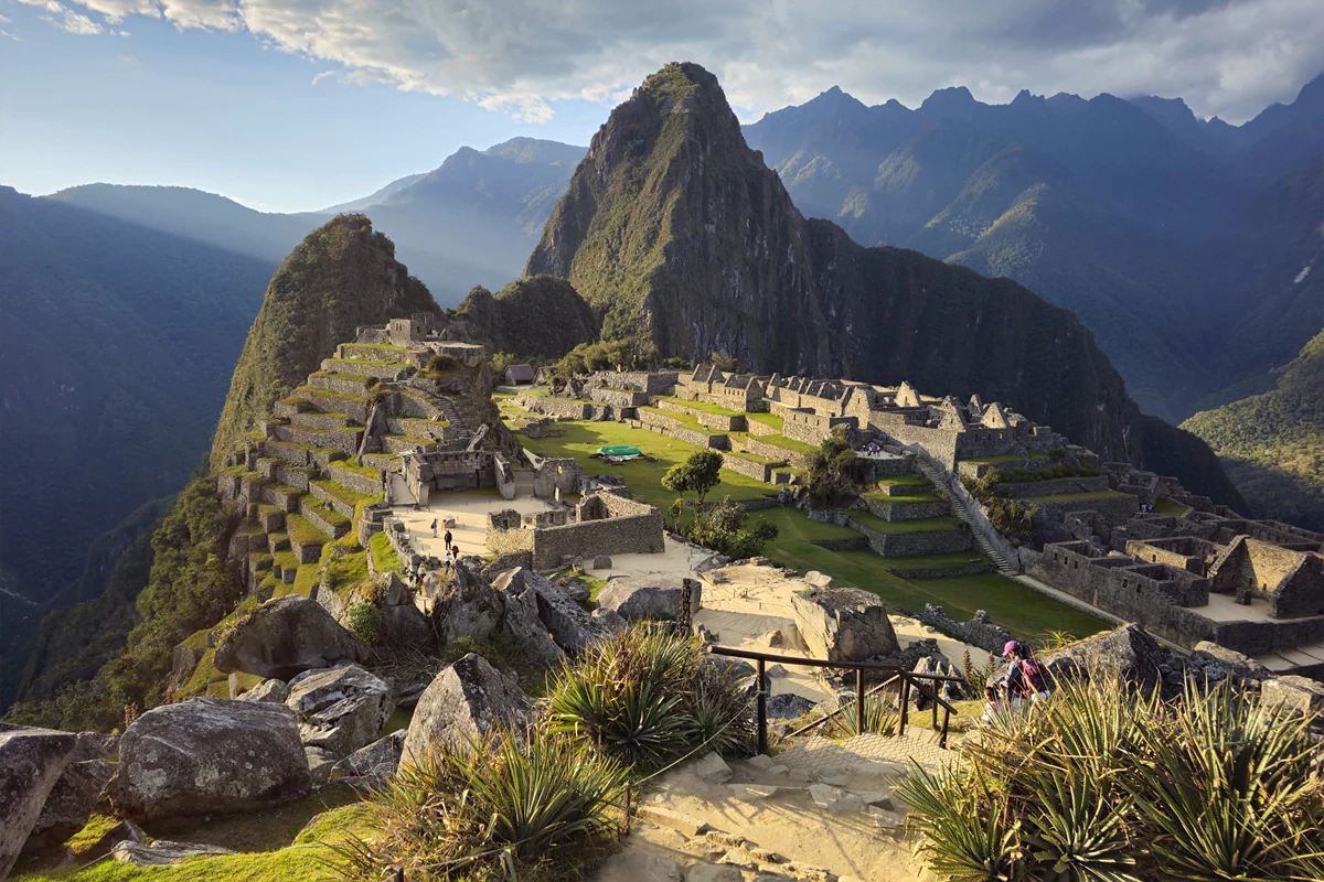 Amanecer dorado iluminando la ciudadela de Machu Picchu en una excursión guiada para viajeros individuales