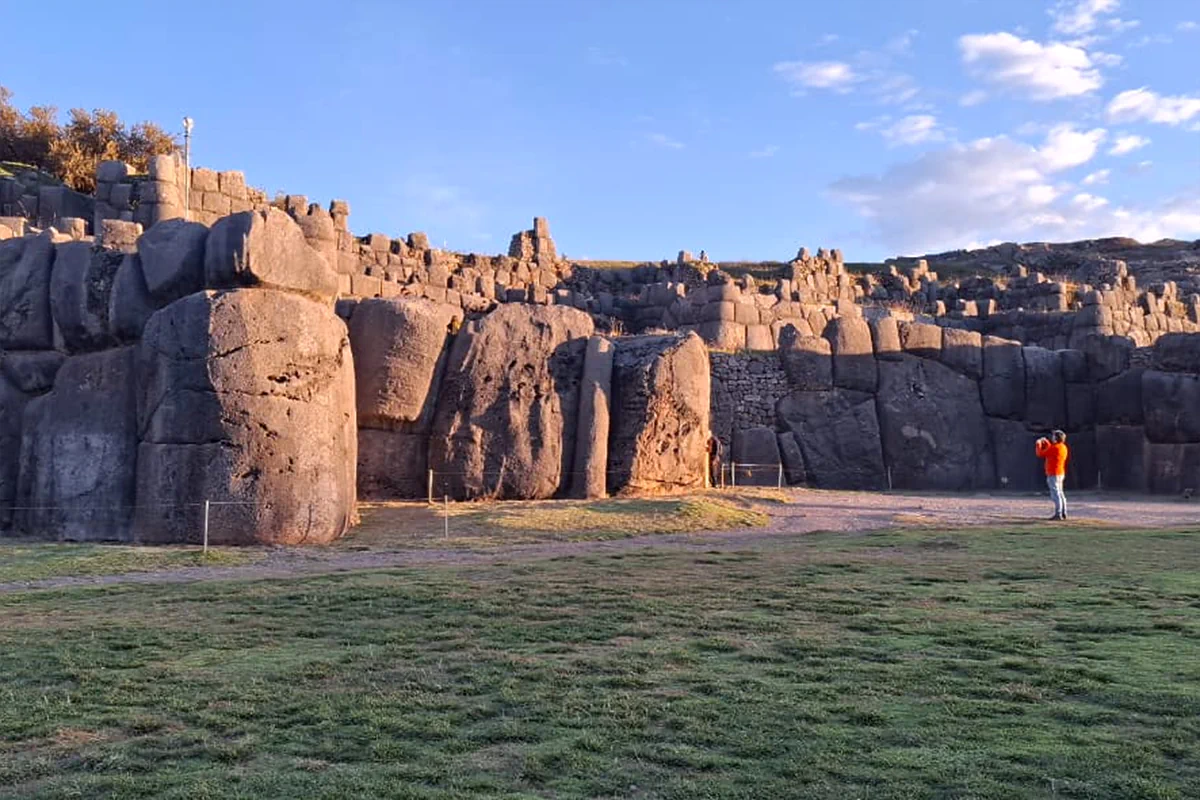Atardecer dorado sobre los baluartes megalíticos de la fortaleza ceremonial de Sacsayhuamán en Cusco, Perú