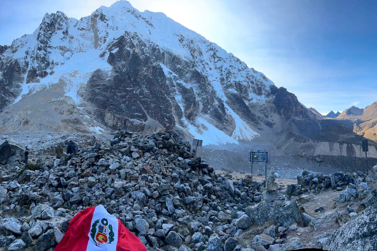 Senderistas alcanzando el paso de alta montaña Abra Salkantay a 4,630 m s. n. m. rodeados de glaciares andinos en Cusco, Perú