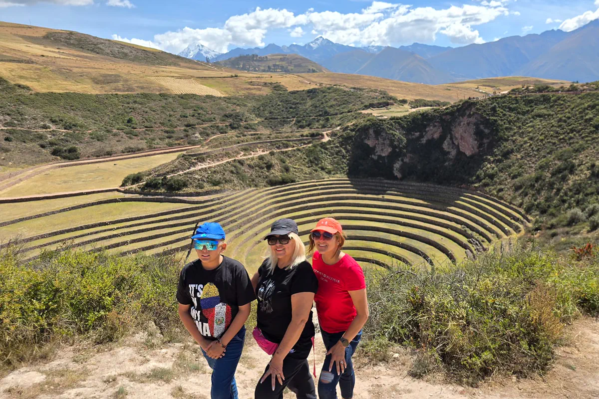Familia con niños y adultos mayores contemplando los andenes concéntricos de Moray en una visita guiada exclusiva