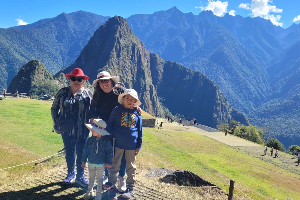 Familia viajando con niños y abuelos frente a la ciudadela inca de Machu Picchu en un tour seguro adaptado a su ritmo