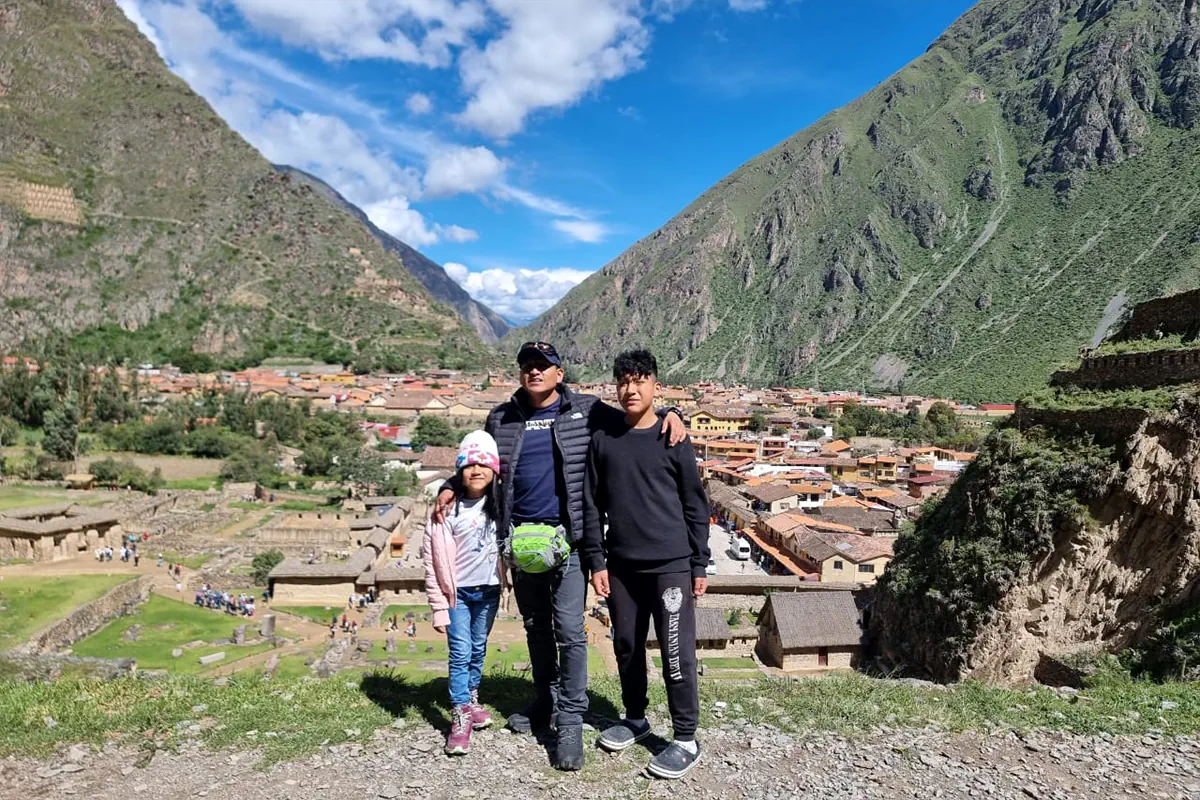 Familia de viajeros caminando por las calles incas de Ollantaytambo en el Valle Sagrado durante su aclimatación a baja altitud