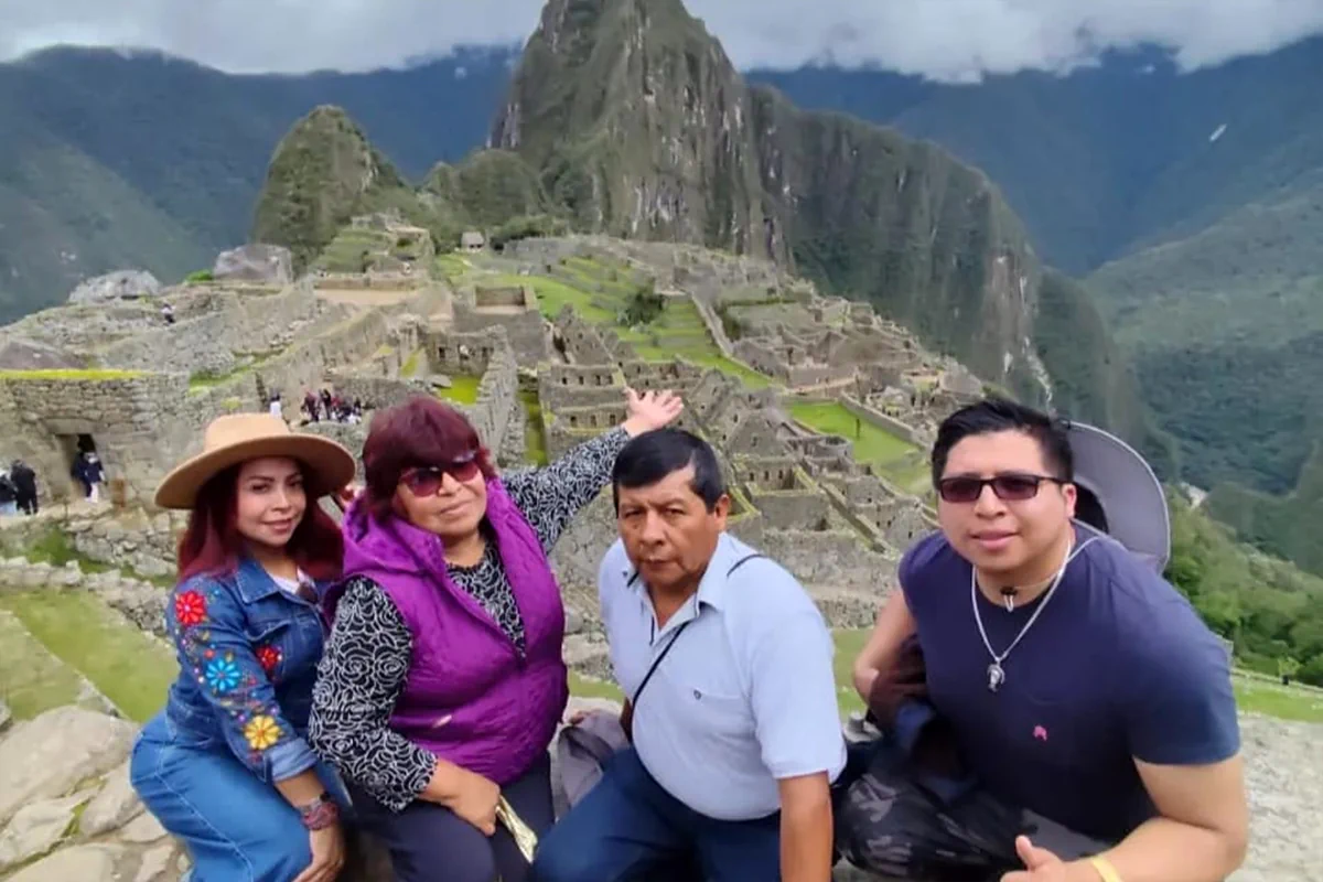 Familia de viajeros con guía oficial exclusivo disfrutando de la vista panorámica de la ciudadela de Machu Picchu en Cusco