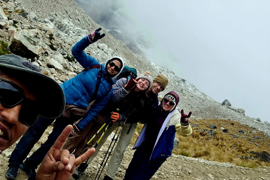 Grupo de viajeros equipados con ropa técnica por capas, bastones de trekking y calzado de montaña en Cusco